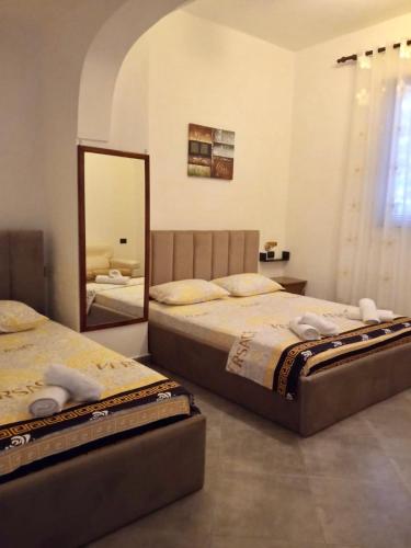 a bedroom with two beds and a mirror at Fati Guest House in Durrës