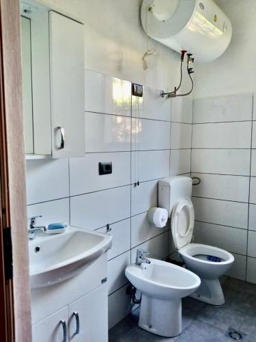 a bathroom with a sink and a toilet and a mirror at Fati Guest House in Durrës