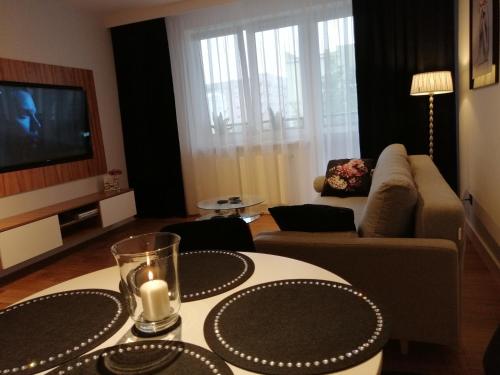 a living room with a couch and a table with a candle at Apartament71 in Płock