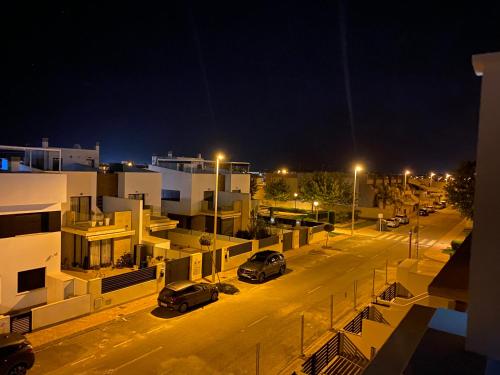 a city at night with cars parked in a parking lot at Luxury Apartment - Rooftop Terrace, community Pool & nearby beach in San Pedro del Pinatar