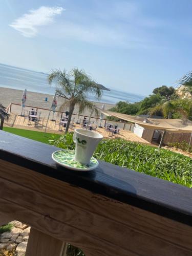 a coffee cup sitting on a table next to the beach at Luxury Apartment - Rooftop Terrace, community Pool & nearby beach in San Pedro del Pinatar