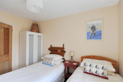 a bedroom with two beds and a picture on the wall at Bedrock in Lyme Regis