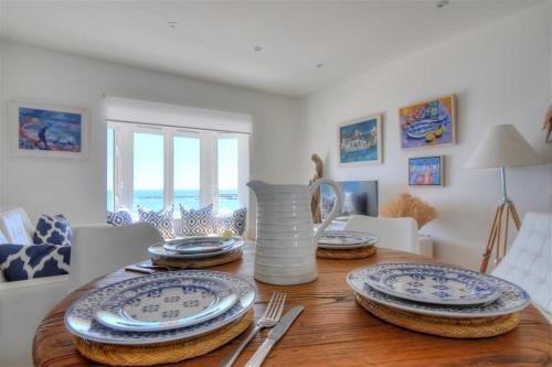a dining room table with plates and a vase on it at Seahorse in Lyme Regis