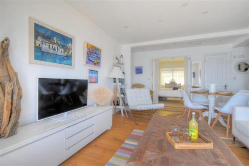 a living room with a flat screen tv on a wall at Seahorse in Lyme Regis