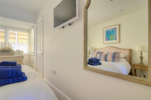 a mirror on the wall of a bedroom with a bed at Seahorse in Lyme Regis