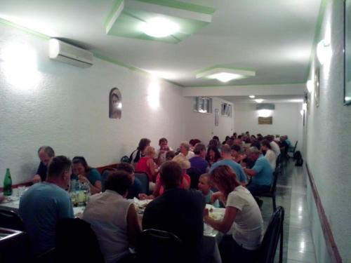 a group of people sitting at tables in a room at Pansion Bojic in Međugorje