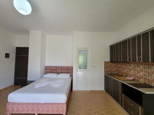 a bedroom with a large bed and a kitchen at Villa Roku in Ksamil