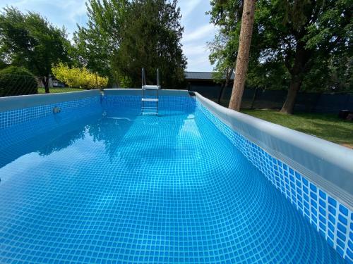 niebieski basen z krzesłem w obiekcie BIKE & FUN Apartments - Balatonakarattya w mieście Balatonakarattya