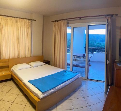 a bedroom with a bed with a view of a balcony at SAINT GEORGE in Karteros