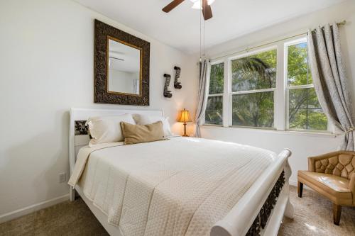 a white bedroom with a bed and a mirror at Wine Country Hideaway in Windsor