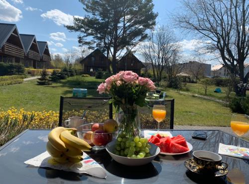 a table with a vase of flowers and fruit on it at Domki Jasna Polana in Jastrzębia Góra