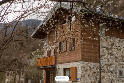 un bâtiment avec un panneau sur son côté dans l'établissement Dolomiti RiverSide, à Perarolo di Cadore