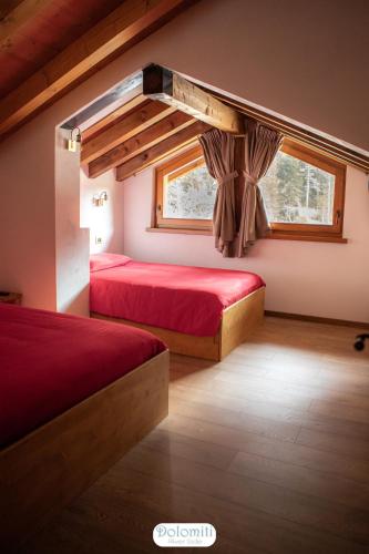 a bedroom with two beds and a window at Dolomiti RiverSide in Perarolo di Cadore