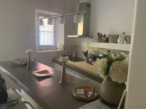 - une cuisine avec un comptoir orné d'un vase de fleurs dans l'établissement LA TREILLE AU COEUR DU VILLAGE, à Saint-Tropez