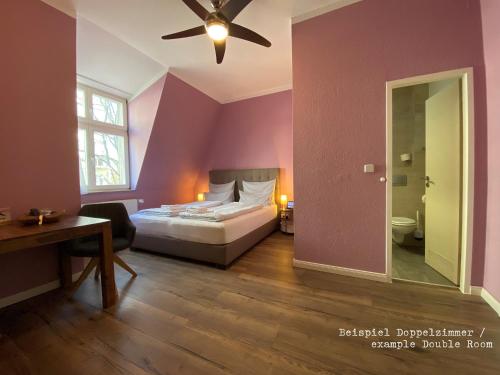 a bedroom with a bed and a ceiling fan at Amaroo - Gästehaus Potsdam “Charlottenhof” in Potsdam