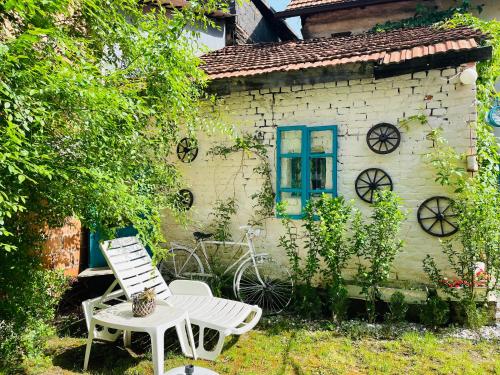 a white chair and a table in front of a house at Apartman Indira in Visoko