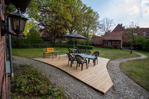 a patio with a table and chairs and an umbrella at Gästehaus Wedework in Wedemark