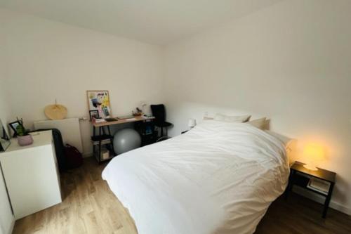 une chambre avec un lit blanc et un bureau dans l'établissement Lumineux appt avec BALCON pour 4 pers à Vannes !, à Vannes