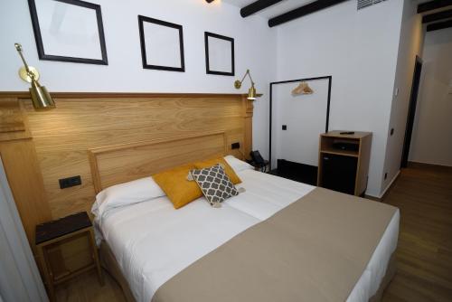 sypialnia z białym łóżkiem z 2 poduszkami w obiekcie Hostal Rural Santa Habitaciones Aldea del Rocío w mieście El Rocío