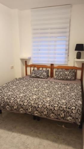 un letto in una camera da letto con una grande finestra di Apartment only 250m from the beach Los Locos a Torrevieja