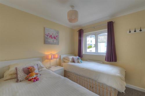 1 dormitorio con 2 camas con animales de peluche en The Old Bakehouse, en Lyme Regis