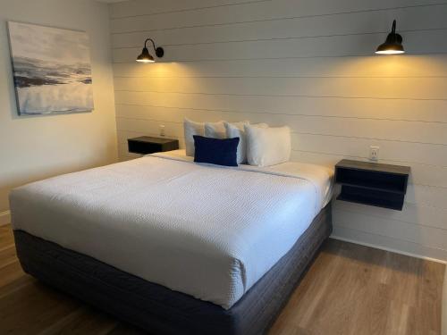 a bedroom with a large white bed with two tables at The ShoreHouse in Ocean City
