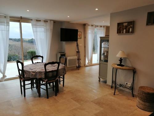 a dining room with a table and chairs and a television at Gites Lou Limbert in Valensole