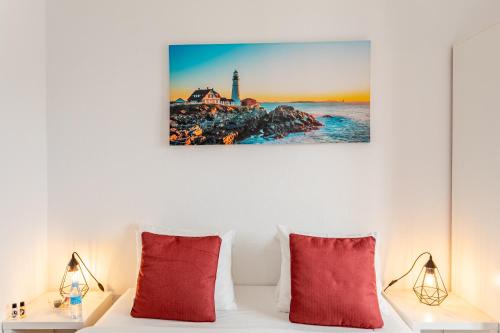 a bedroom with a bed with red pillows and a lighthouse at Encarnação Home in Lisbon