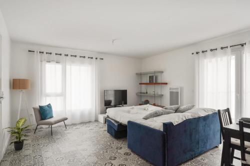 1 dormitorio con 1 cama grande y 1 silla en Appartement des Tours - Welkeys en La Rochelle