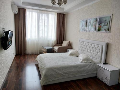 a bedroom with a bed and a chair in it at Альтаир1 in Odesa