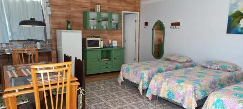 a hotel room with two beds and a microwave at Pousada Minha Casa in São Lourenço