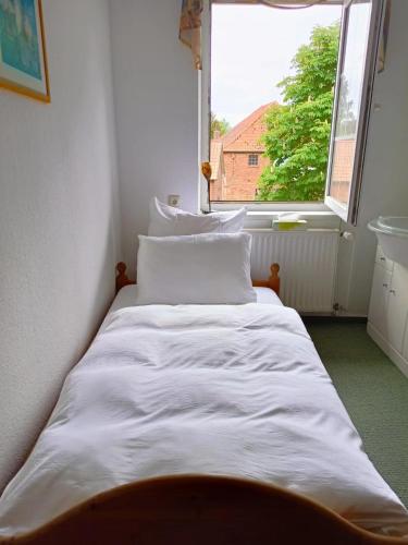 a white bed in a room with a window at Altenmedinger Hof in Altenmedingen