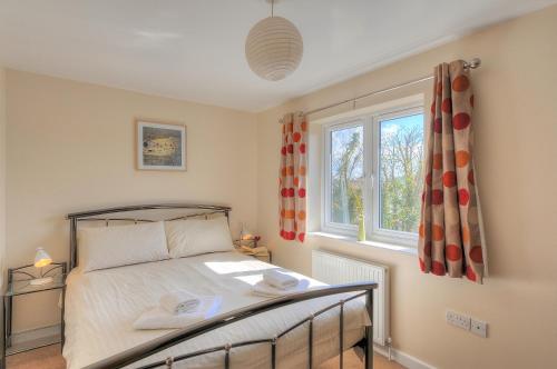 a bedroom with a bed and a window at Undercliff in Lyme Regis