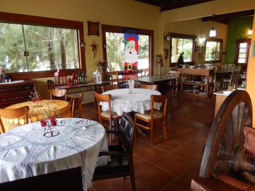 ランバリにあるPousada Lambari Montanha Hotelのテーブルと椅子、窓際のサンタ帽子付きのレストラン