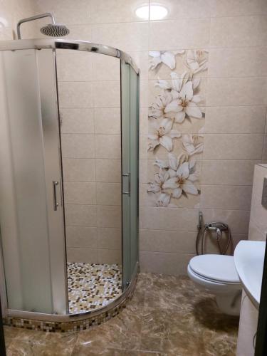 a shower stall in a bathroom with flowers on the wall at Альтаир1 in Odesa