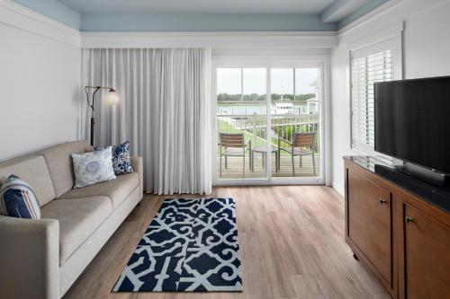 a living room with a couch and a flat screen tv at Beaufort Hotel in Beaufort