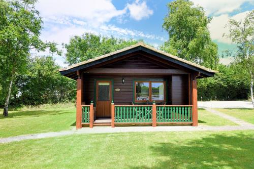 a small cabin with a porch in a park at 4 Pinewood Retreat in Lyme Regis