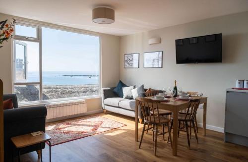 a living room with a table and a couch at 2 Beach Way House in Lyme Regis