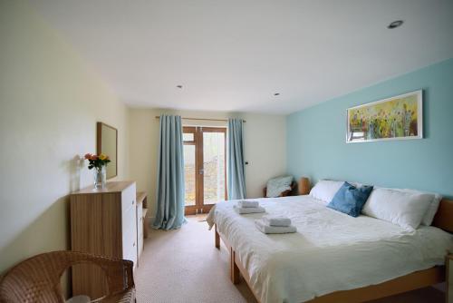 a bedroom with a large bed and a window at Pippin in Charmouth
