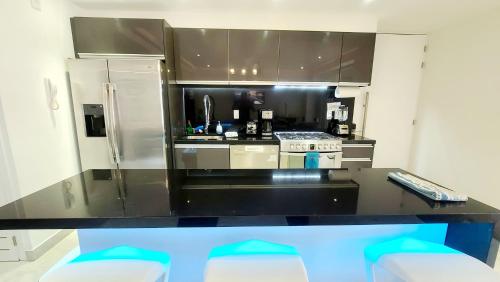 a kitchen with a black counter top and a refrigerator at Departamento Zona Romantica in Puerto Vallarta