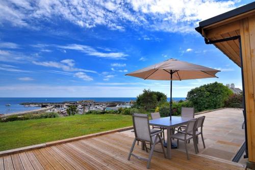 a patio with a table and chairs and an umbrella at Harbour Heights Cottage in Lyme Regis