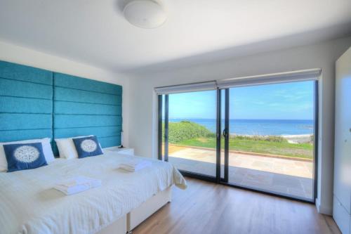 a bedroom with a large bed and a view of the ocean at Harbour Heights Cottage in Lyme Regis