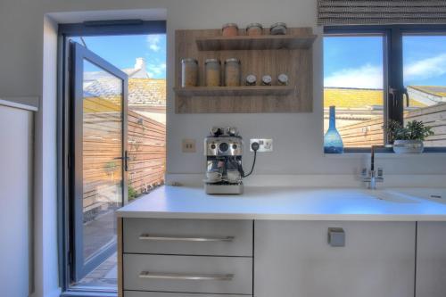 uma cozinha com uma batedeira num balcão ao lado de uma janela em 3 Grove Mews em Seaton