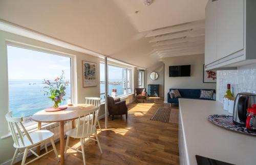 a kitchen and living room with a table with a view of the ocean at 3 Beach Way House in Lyme Regis