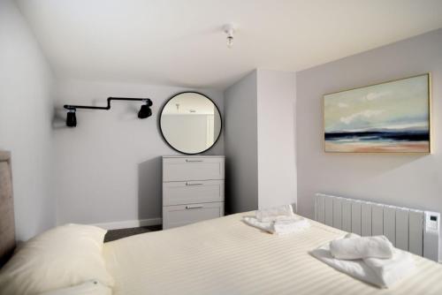 a bedroom with a bed and a mirror at Pebbles in Lyme Regis