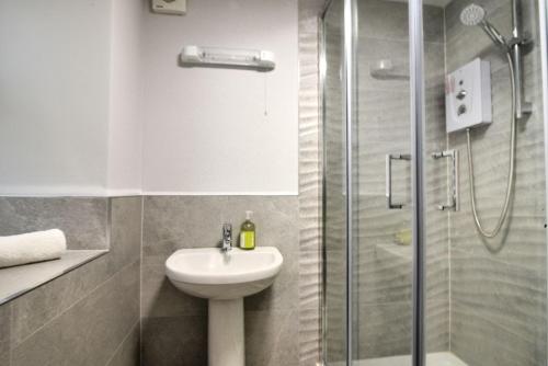 a bathroom with a toilet sink and a shower at Pebbles in Lyme Regis