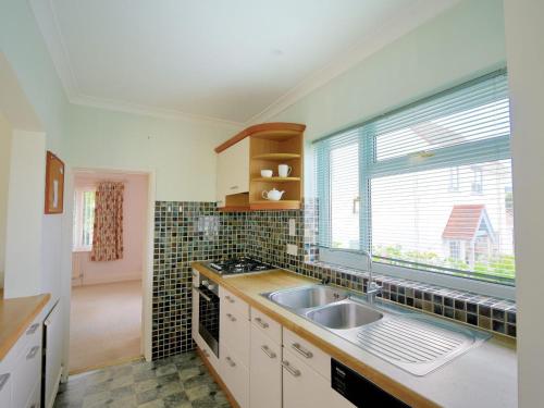 une cuisine avec un évier et une fenêtre dans l'établissement Oak Tree, à Lyme Regis