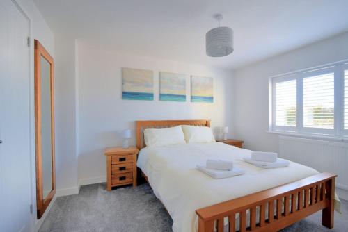een slaapkamer met een groot bed met twee dienbladen erop bij Shire View in Lyme Regis