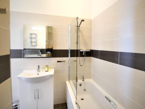 ein Badezimmer mit einem Waschbecken, einer Dusche und einer Badewanne in der Unterkunft Ocean View in Seaton