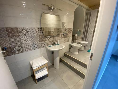 a bathroom with a sink and a toilet and a mirror at Pompei Civico 84 in Scafati